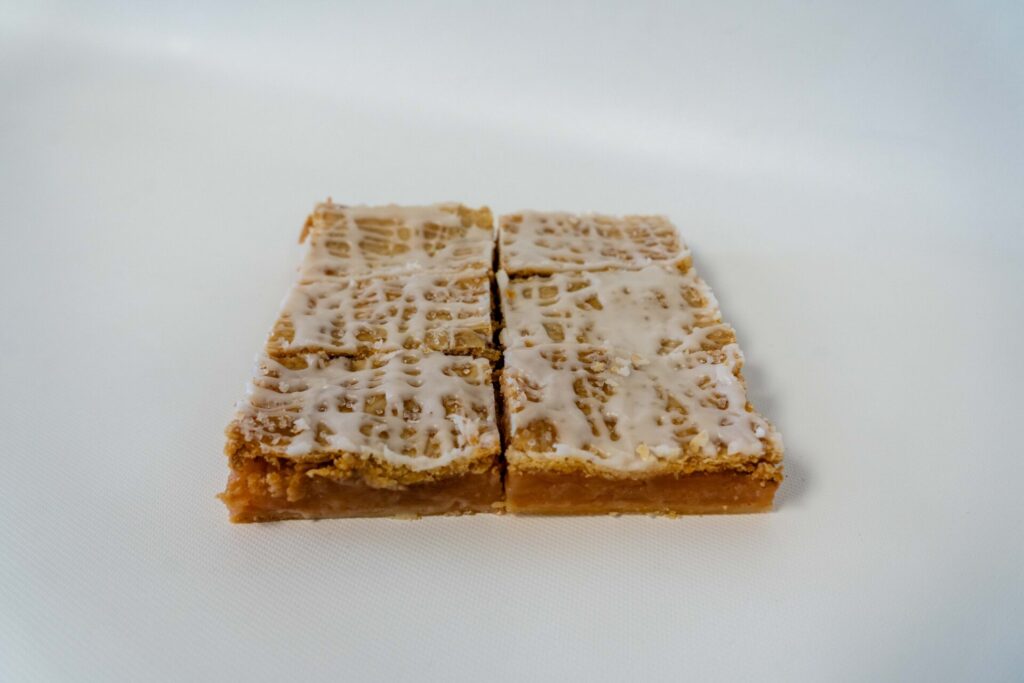 Slice of Apple Pie showing layers of tender, cinnamon-spiced apples in a golden, flaky crust, served warm.