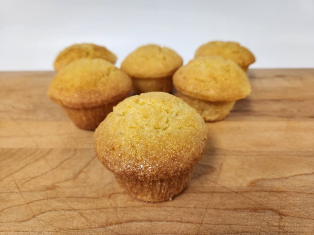 Corn Muffins with a golden, slightly crisp top and a moist, crumbly interior, served warm for a classic comfort treat.