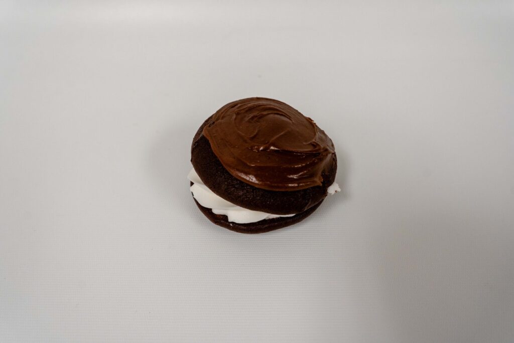 Gluten-Free Whoopie Pie with two soft chocolate cake rounds and a fluffy vanilla creme filling in the center.