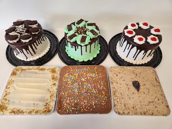 Group image showing a variety of tortes and sheet cakes with assorted flavors and decorative toppings, displayed side by side for a dessert selection.