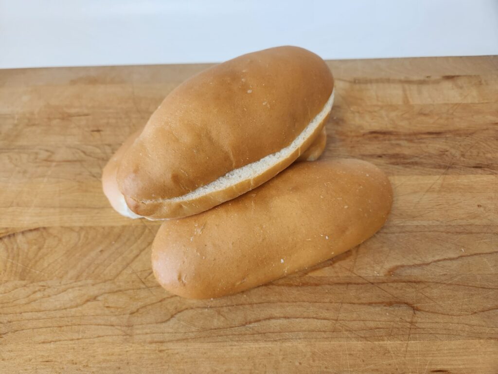 Freshly baked hoagie buns with a golden-brown crust and soft, airy interior, perfect for sandwiches and subs.