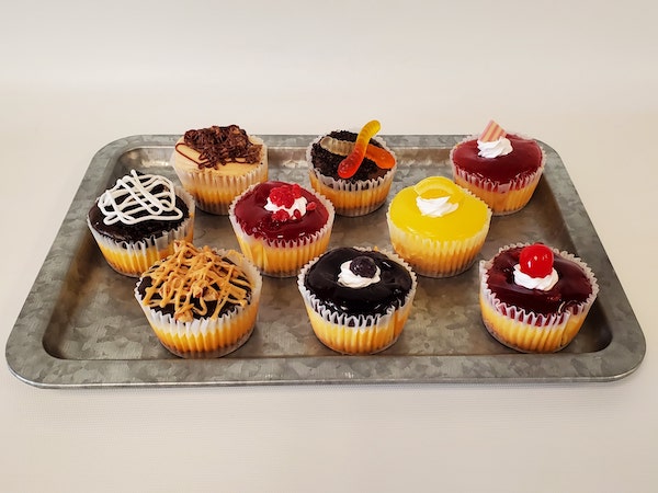 Individual mini cheesecakes with smooth, creamy filling in graham cracker crusts, served in small portions perfect for single servings.