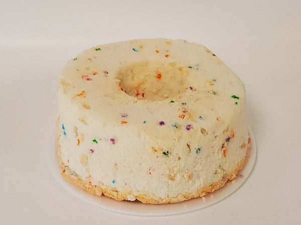 Confetti Angel Food Cake with a light, fluffy texture and colorful sprinkles baked throughout, topped with a sugar glaze or served plain.