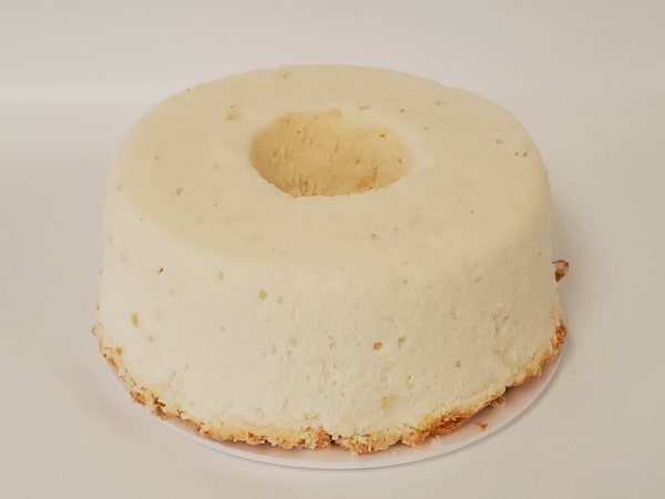 Classic Angel Food Cake with a light, airy texture and golden exterior, served plain or ready for fruit and whipped cream toppings.