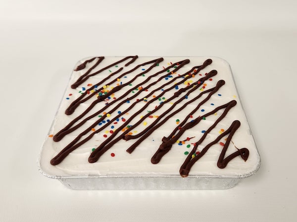 Marble Snack Cake with swirls of vanilla and chocolate, topped with a rich chocolate drizzle and colorful sprinkles for a fun, sweet treat.