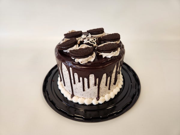 Mini Oreos and Cream Whipped Cream Torte with layers of fluffy whipped cream, crushed Oreo cookies, and a soft cake base, topped with cookie pieces.