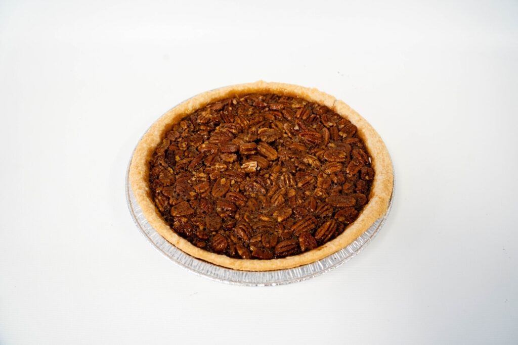 Classic Pecan Pie featuring a rich, buttery filling and a crisp layer of whole pecans, baked in a golden pie shell.