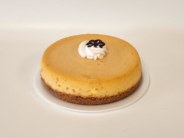 Plain mini cheesecake with a creamy, smooth filling on a golden graham cracker crust, served without toppings for a classic look.