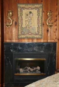 The Kiss tapestry above a fireplace